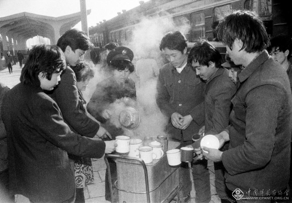 原瑞伦-1982年早春时节，东北地区仍是寒风刺骨，春寒料俏，旅客们在通辽车站站台上排队打热水。摄影原瑞伦.jpg