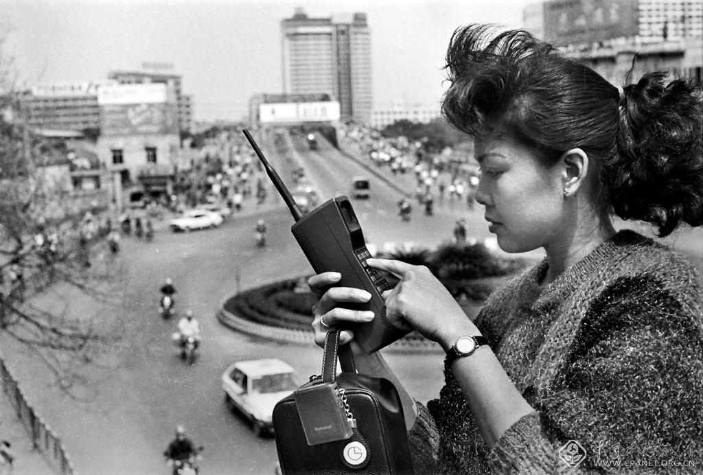 叶健强----大姐大“打”大哥 大 上个世纪八十年代，穿着时髦的靓女，当街捧个水壶般的“大哥大”。当时这把“壶”算是一种身份与财富的象征。叶健强1987年摄于广州江南.jpg