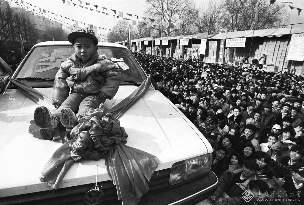 胡金喜-《中奖者》，1997摄，四川来京民工伍富贞家3岁的孩子幸运中得一轿车.jpg