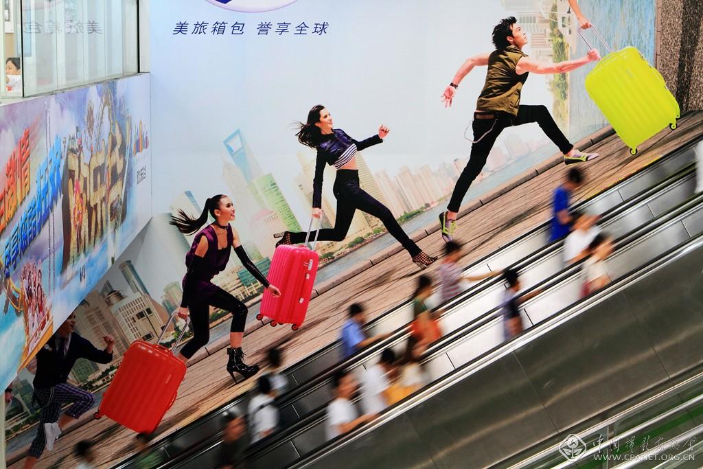 陈欣-《上海节奏》 ，2012-7，上海的发展速度在广告的背景里淋漓尽致体现，在上海最繁华的人民广场地铁站，我用相机定格了这个画面。.jpg