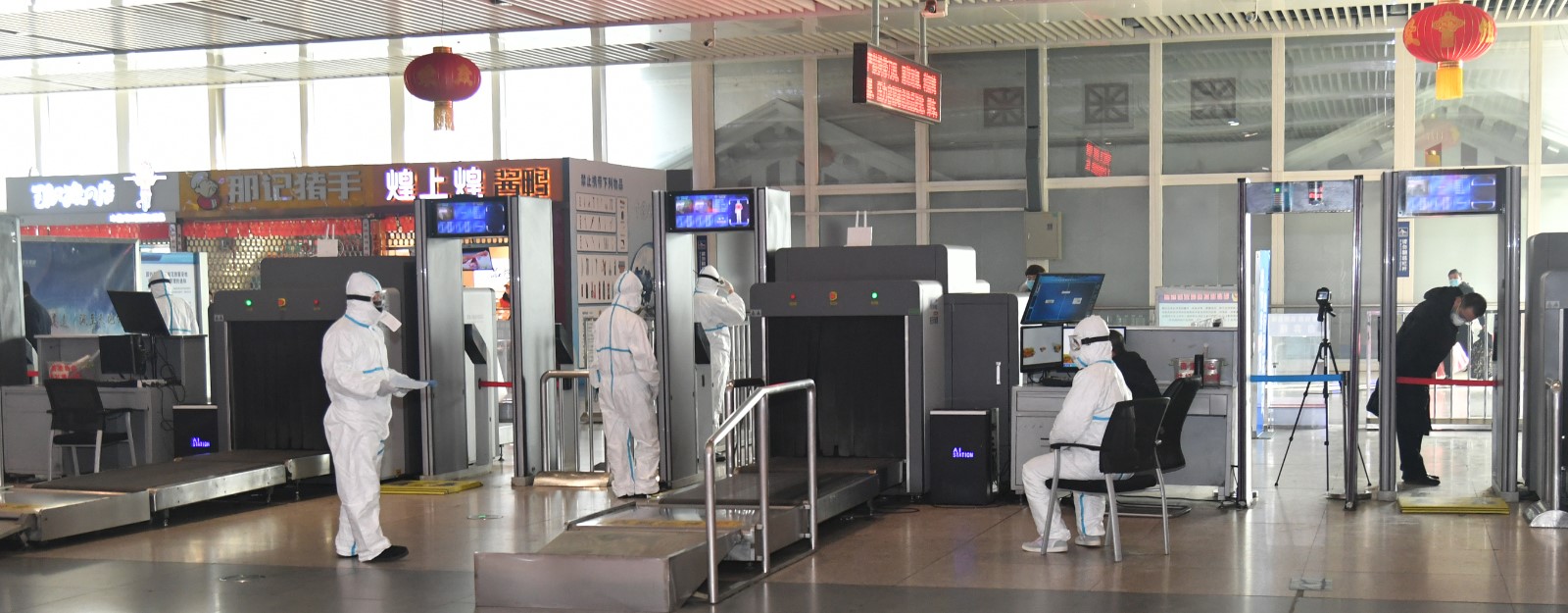 1月28日,沈阳站安检口,工作人员严阵以待,坚守岗位为旅客测体温.