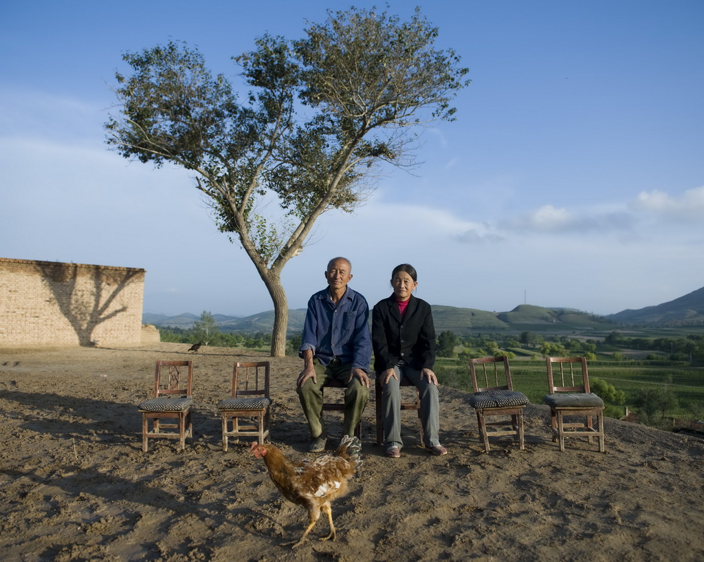 陕西省靖边县席麻湾乡，61岁的王贵贤（左）和老伴张树美在家门前（2011年8月24日摄）。王贵贤有4个孩子离开村子外出打工。